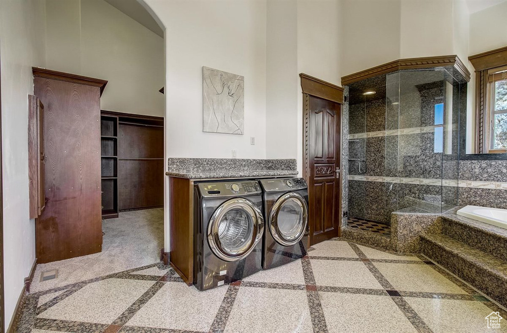 Laundry room with a high ceiling and washer and dryer