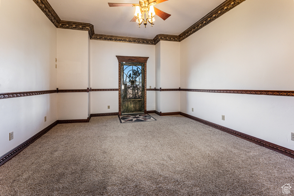 Spare room with carpet, ceiling fan, and crown molding
