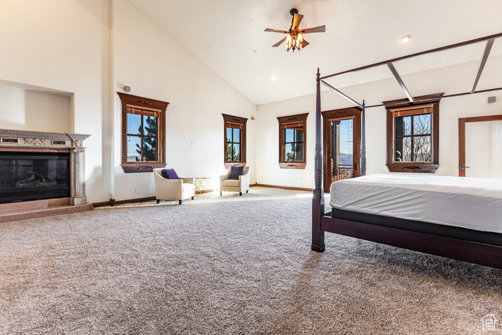 Unfurnished bedroom with high vaulted ceiling, ceiling fan, and carpet floors