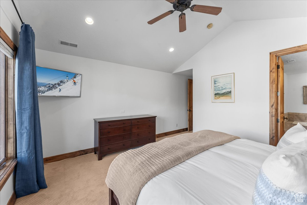 Bedroom featuring ceiling fan, vaulted ceiling, and light colored carpet
