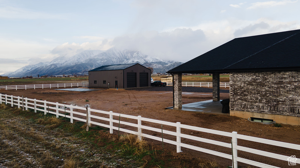 View of stable featuring a mountain view, a rural view, and an outdoor structure