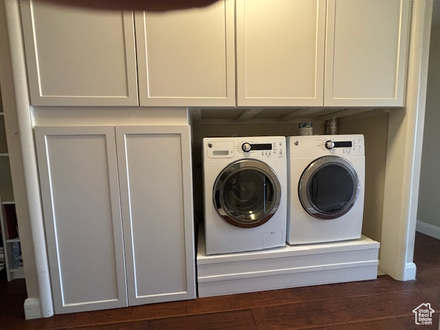 Laundry area with dark hardwood / wood-style flooring, cabinets, and washer and clothes dryer