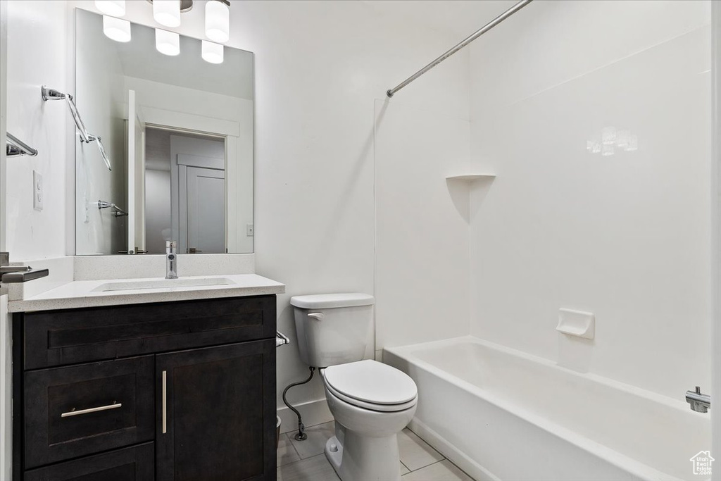 Full bathroom with shower / bathtub combination, tile flooring, toilet, and vanity