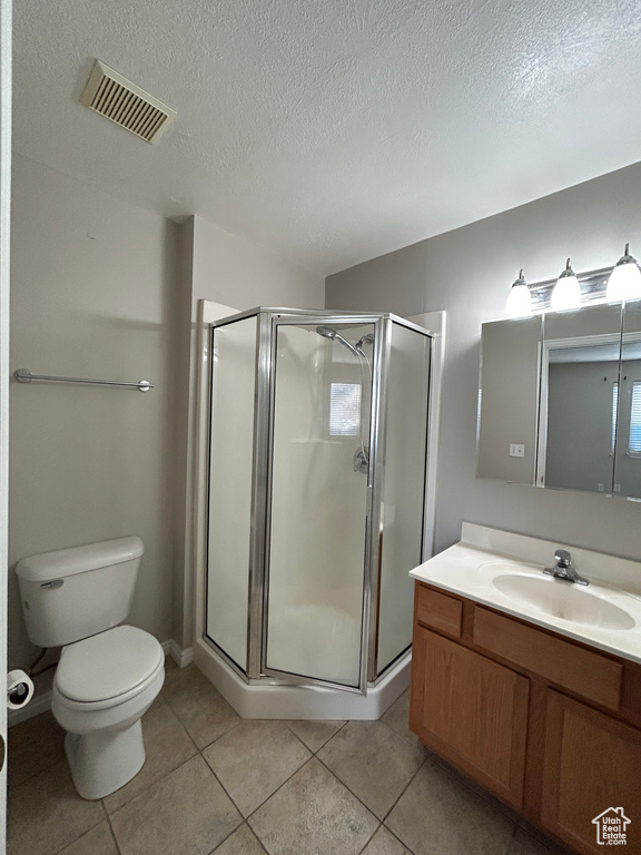 Bathroom featuring vanity, tile flooring, toilet, and walk in shower