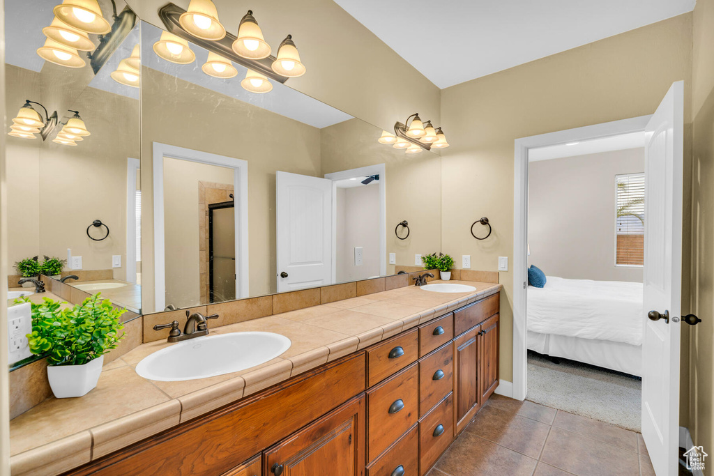 Bathroom with oversized vanity, tile flooring, and dual sinks