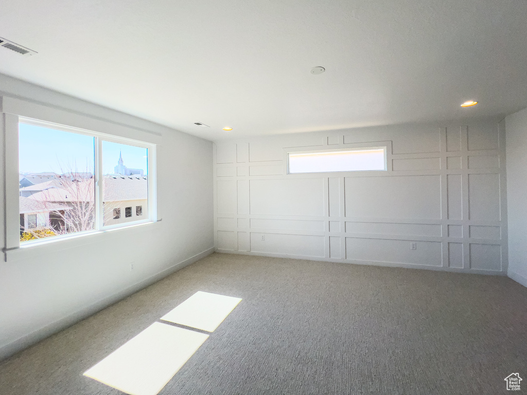 Unfurnished room with a wealth of natural light and light colored carpet