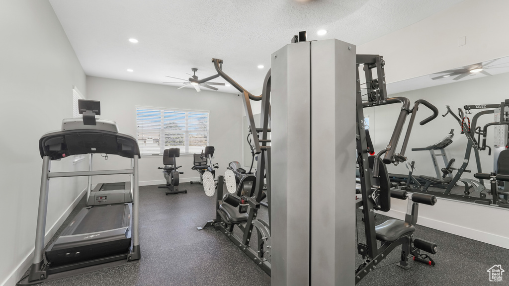 Gym with ceiling fan and a textured ceiling