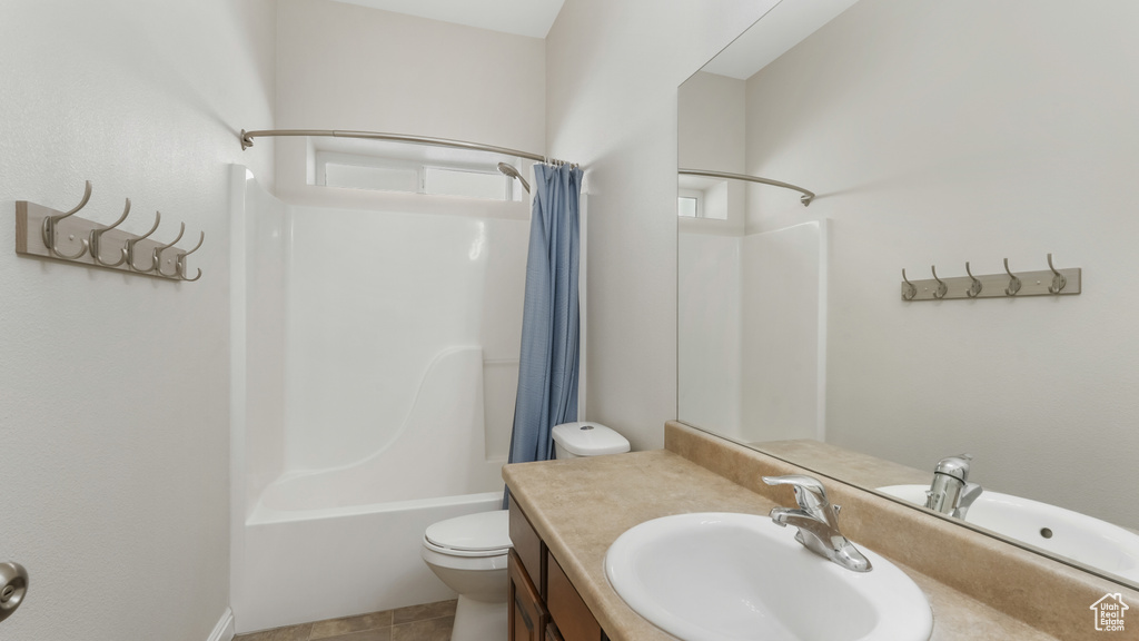 Full bathroom featuring toilet, shower / tub combo, tile floors, and vanity