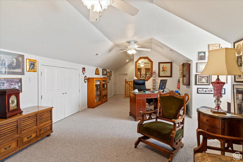 Interior space featuring light carpet, vaulted ceiling, and ceiling fan