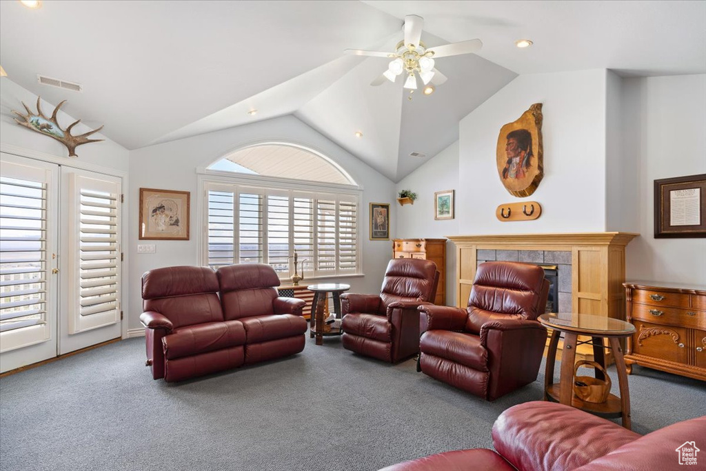 Living room with plenty of natural light, a tile fireplace, carpet flooring, and ceiling fan
