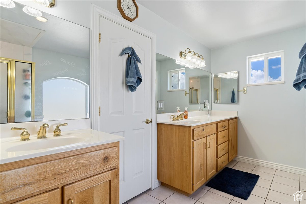 Bathroom with plenty of natural light, double sink vanity, and tile flooring