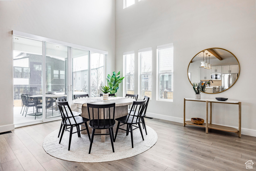 Dining space featuring light hardwood / wood-style floors and a high ceiling