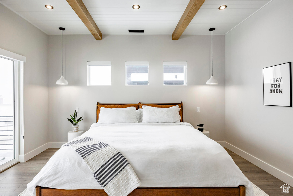 Bedroom with multiple windows and dark hardwood / wood-style flooring