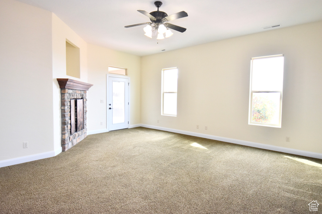 Spare room with light carpet, a fireplace, and ceiling fan