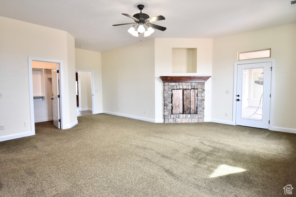 Unfurnished living room with dark carpet, ceiling fan, and a fireplace