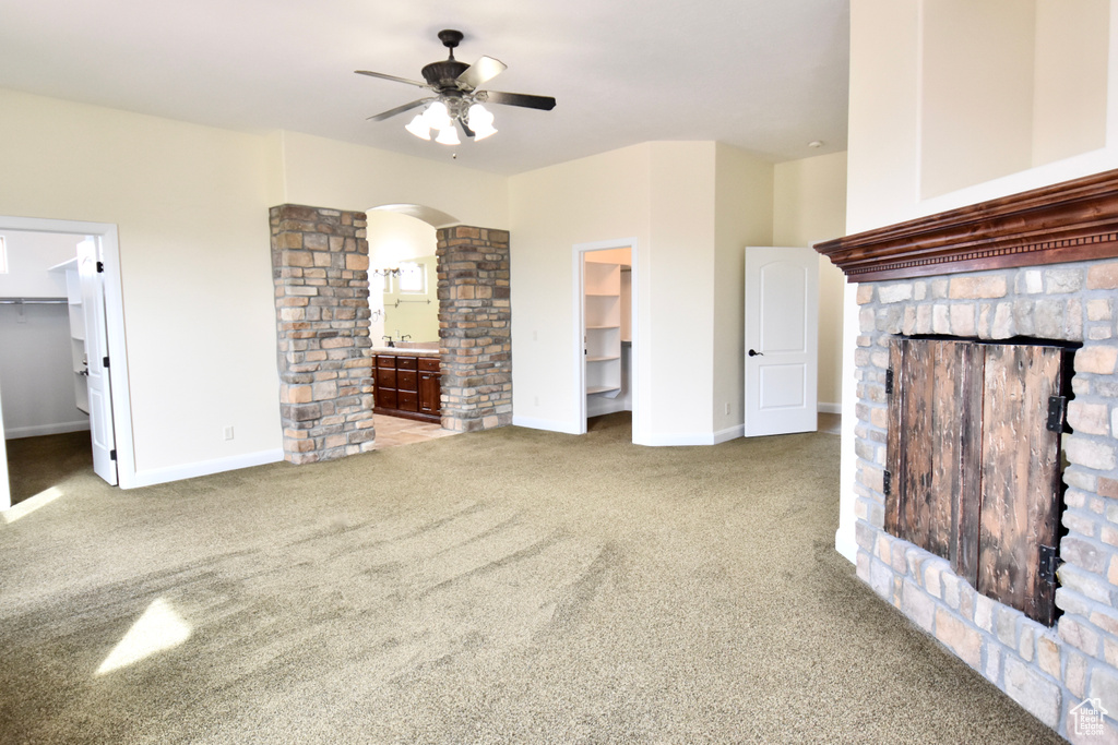 Unfurnished living room with light carpet, ceiling fan, and sink