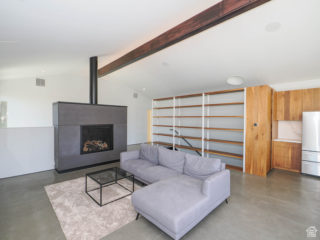 Living room featuring concrete floors and vaulted ceiling with beams