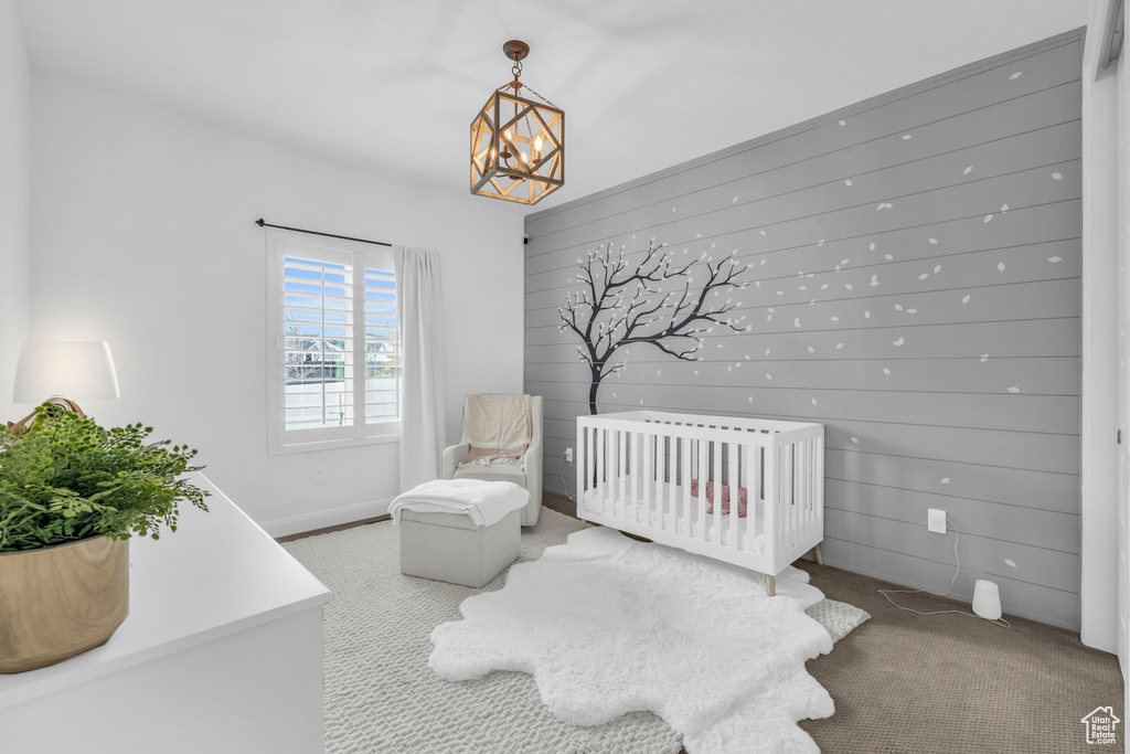 Bedroom featuring a nursery area, a chandelier, and light colored carpet