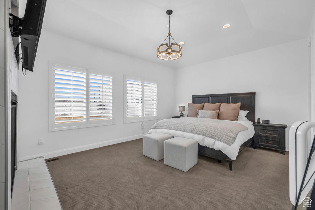 Bedroom featuring a chandelier, vaulted ceiling, and light colored carpet