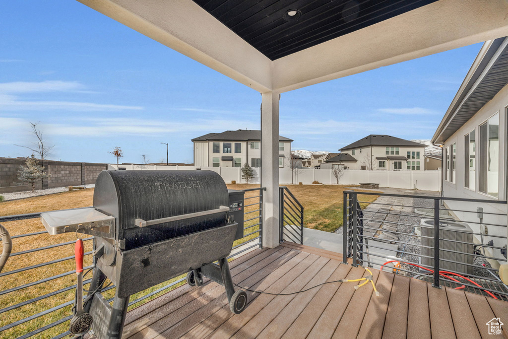 Wooden deck featuring area for grilling and a lawn