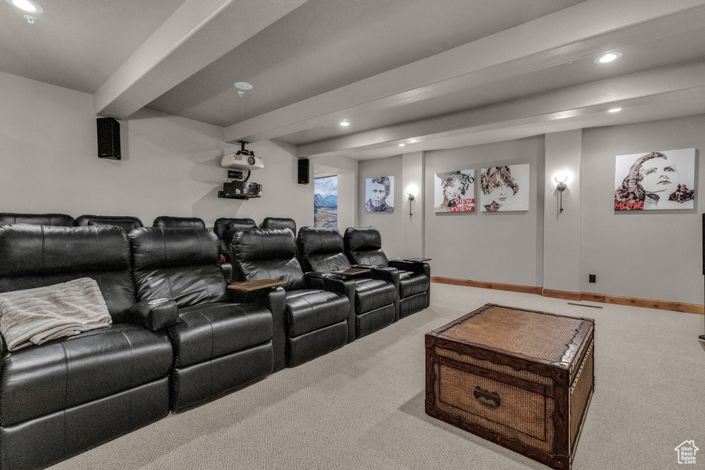 Carpeted home theater with beamed ceiling