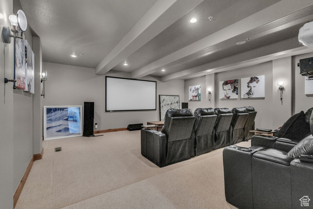 Cinema room with beam ceiling and light colored carpet