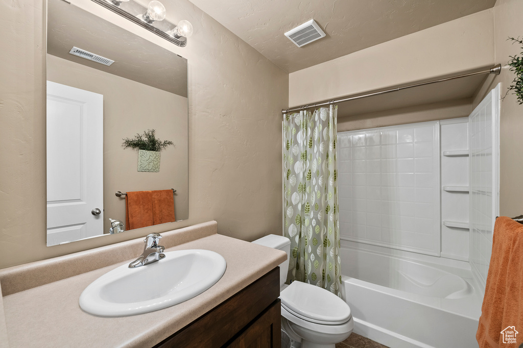 Full bathroom with toilet, shower / bathtub combination with curtain, and vanity