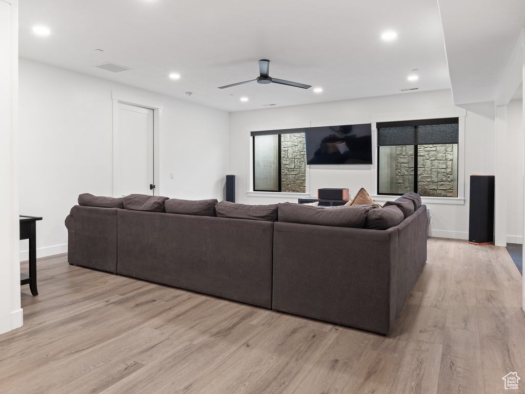 Cinema featuring light hardwood / wood-style floors and ceiling fan