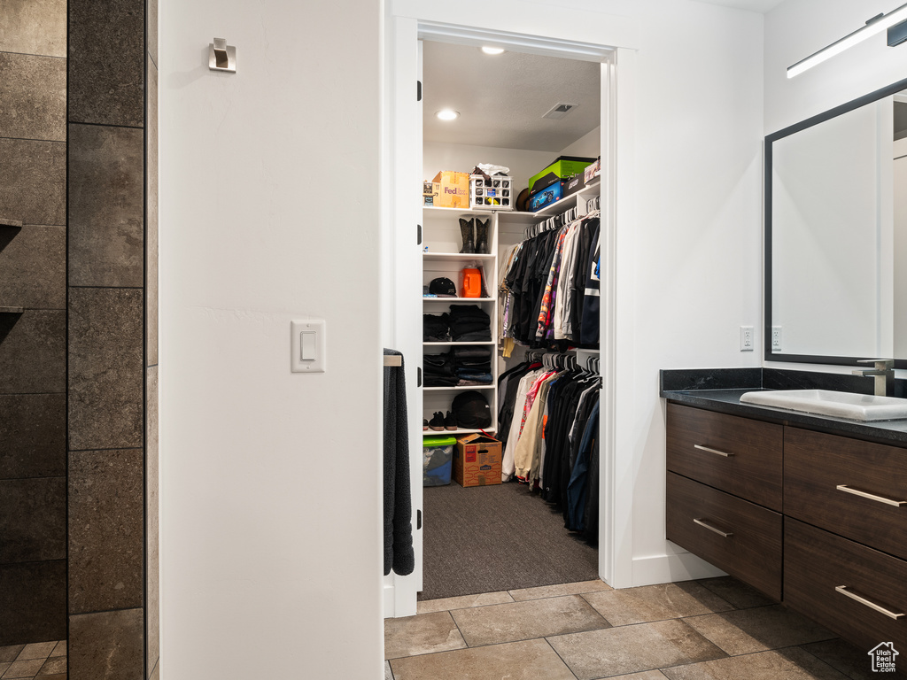 Spacious closet featuring light tile floors and sink