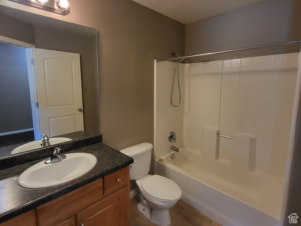 Full bathroom with vanity, shower / tub combination, tile floors, a textured ceiling, and toilet