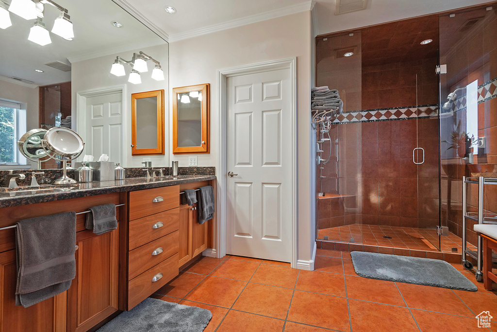 Bathroom with an enclosed shower, tile floors, dual bowl vanity, and ornamental molding