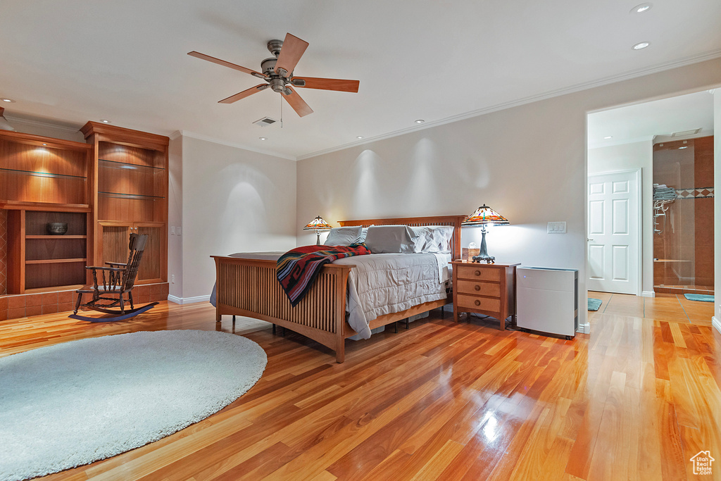 Bedroom with connected bathroom, ornamental molding, ceiling fan, and light hardwood / wood-style flooring