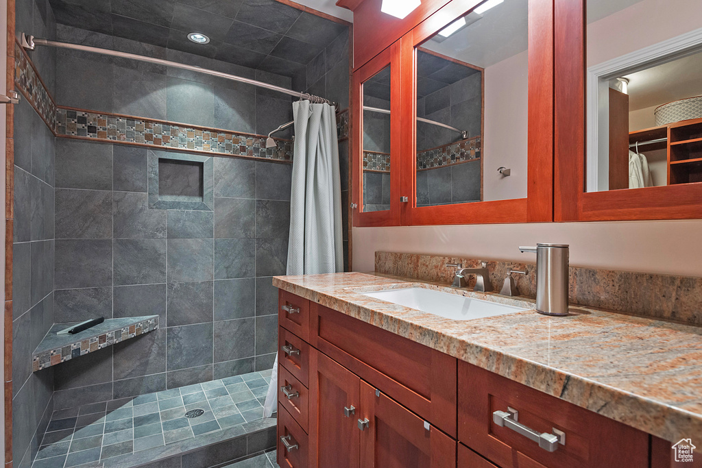 Bathroom featuring a shower with shower curtain and vanity