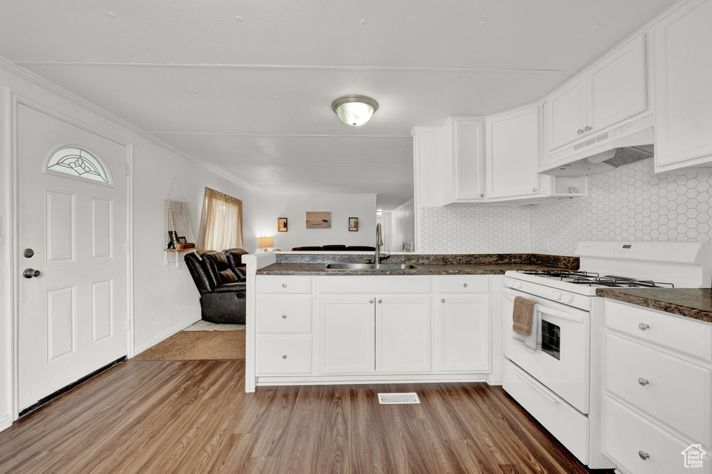 Kitchen featuring sink, white cabinets, white range with gas cooktop, light hardwood / wood-style flooring, and backsplash