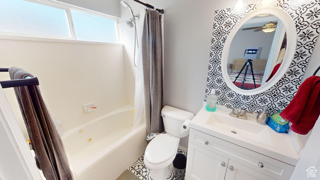 Full bathroom featuring toilet, shower / bath combo, ceiling fan, and oversized vanity