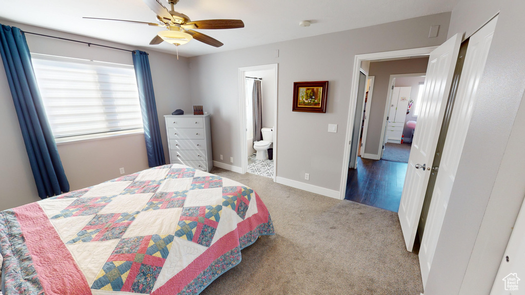 Carpeted bedroom featuring connected bathroom and ceiling fan