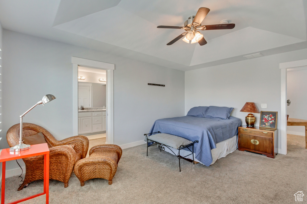 Carpeted bedroom with ceiling fan, a raised ceiling, and ensuite bathroom