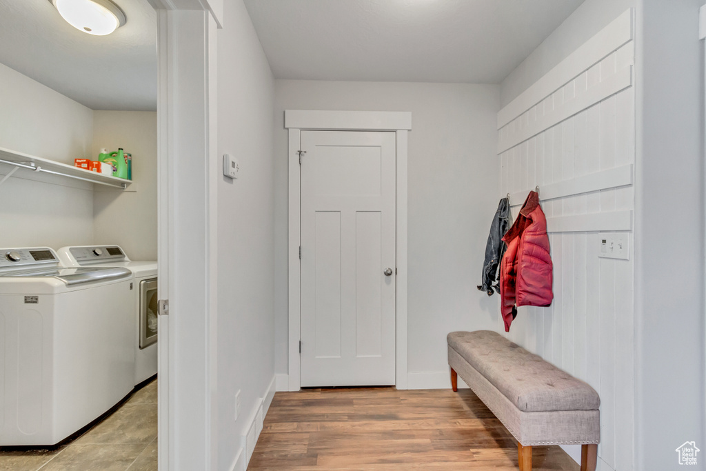 Mudroom featuring light tile floors and washing machine and clothes dryer