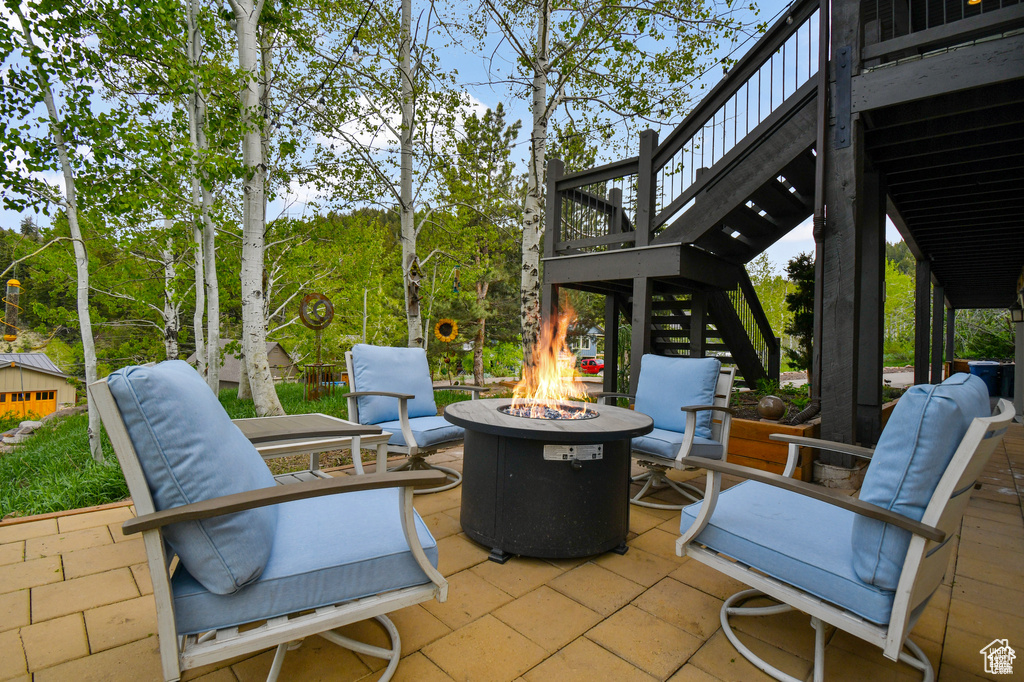 View of patio / terrace featuring an outdoor fire pit and a deck