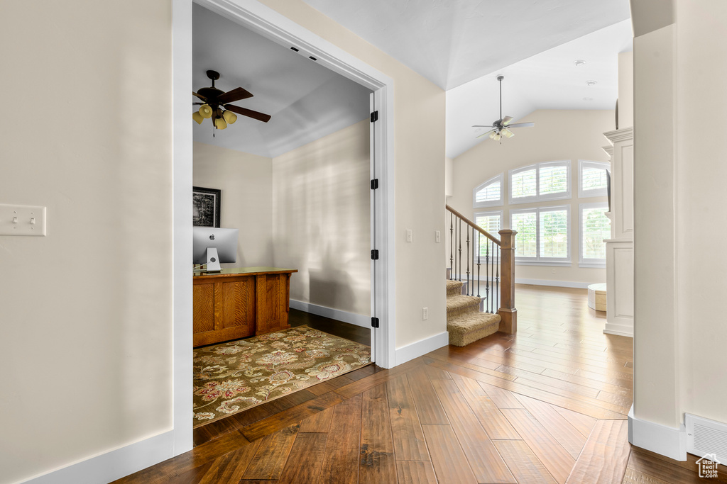 Foyer entrance with lofted ceiling, dark hardwood / wood-style floors, and ceiling fan