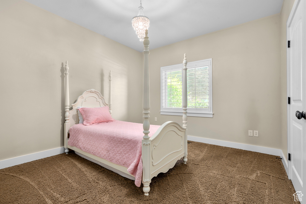 Carpeted bedroom with a chandelier