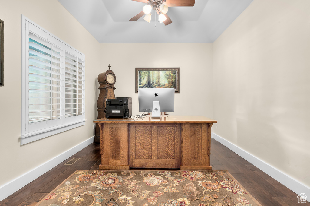 Office space featuring plenty of natural light, ceiling fan, and dark hardwood / wood-style flooring