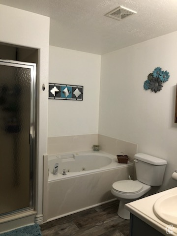 Full bathroom featuring toilet, hardwood / wood-style flooring, a textured ceiling, vanity, and shower with separate bathtub