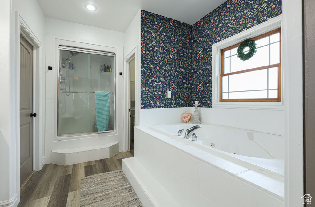 Bathroom with shower with separate bathtub and hardwood / wood-style flooring
