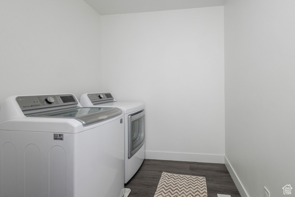 Washroom with separate washer and dryer and dark hardwood / wood-style floors