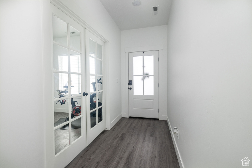 Doorway to outside with dark hardwood / wood-style floors