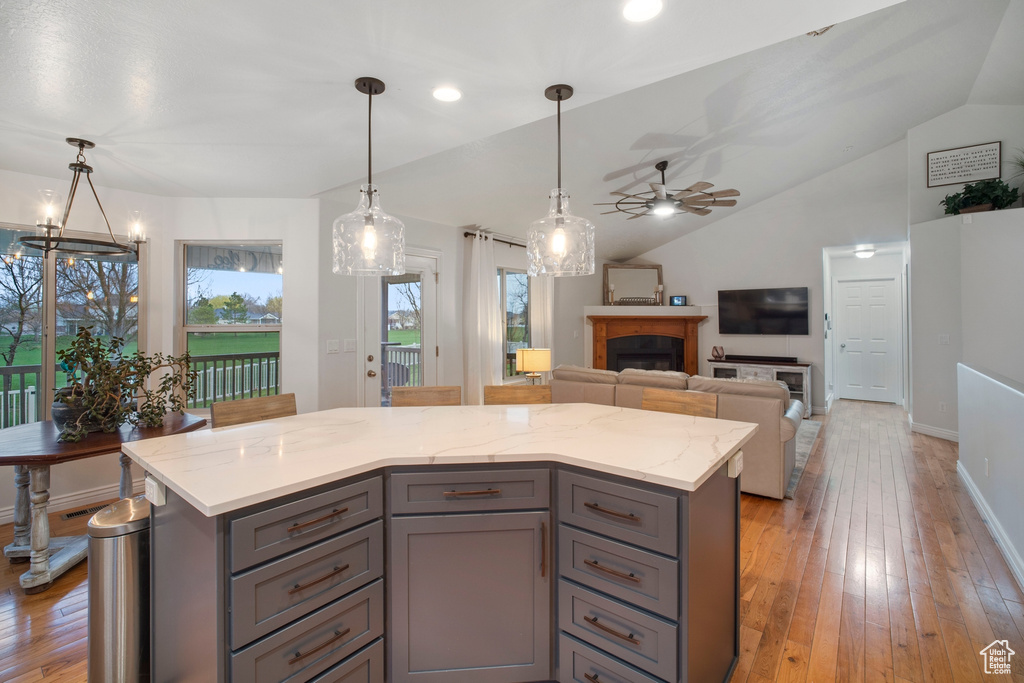 Kitchen featuring a kitchen island, light hardwood / wood-style flooring, and ceiling fan with notable chandelier
