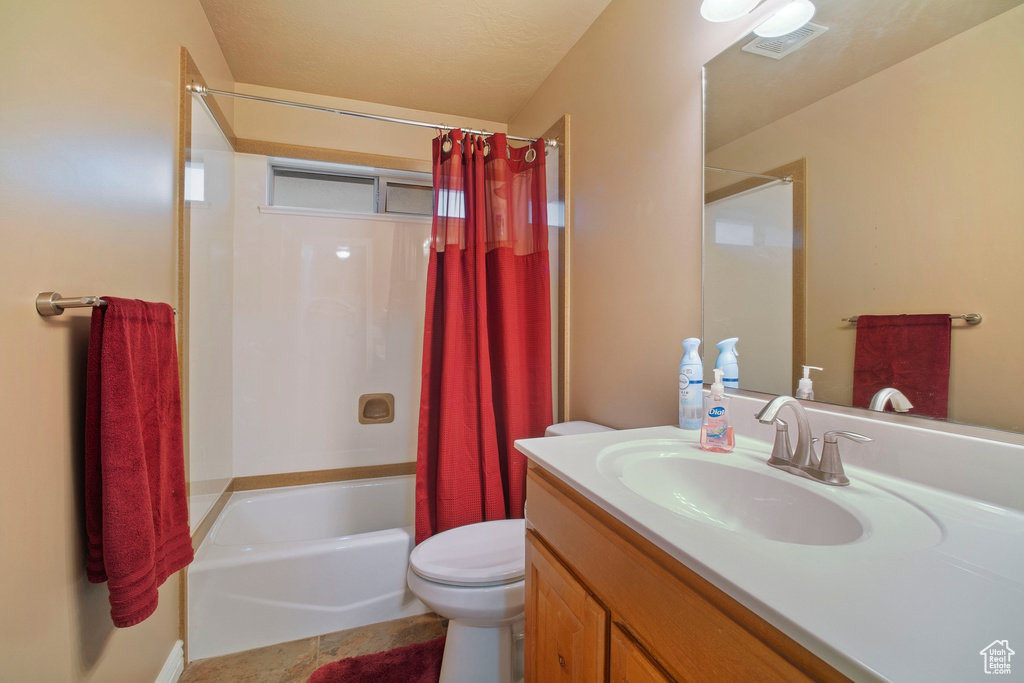 Full bathroom with tile flooring, toilet, shower / bath combo, and oversized vanity