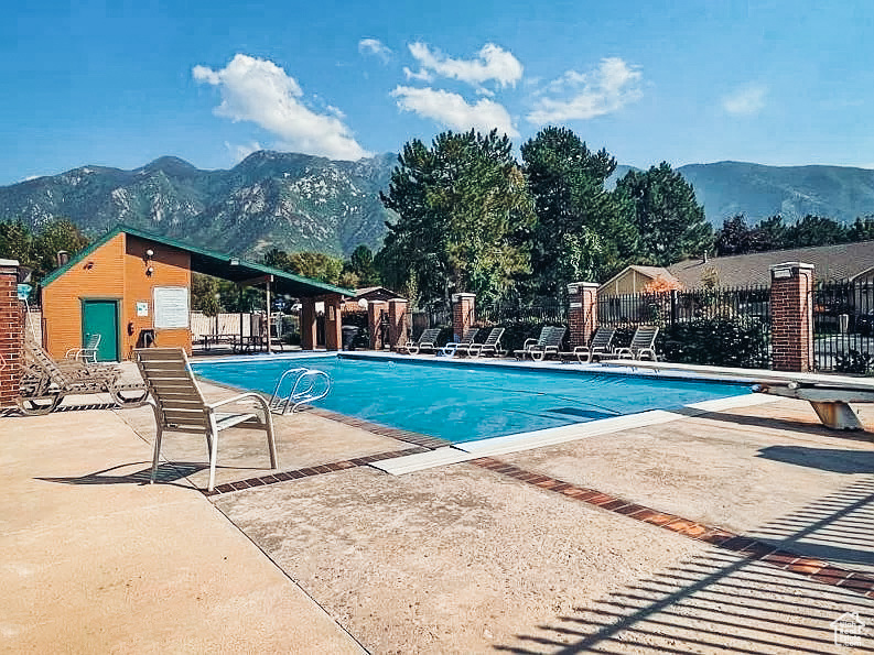 View of pool with a mountain view and a patio