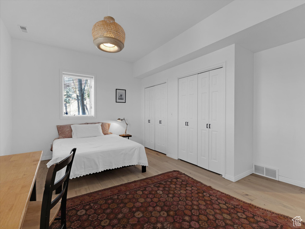 Bedroom featuring multiple closets and light hardwood / wood-style floors